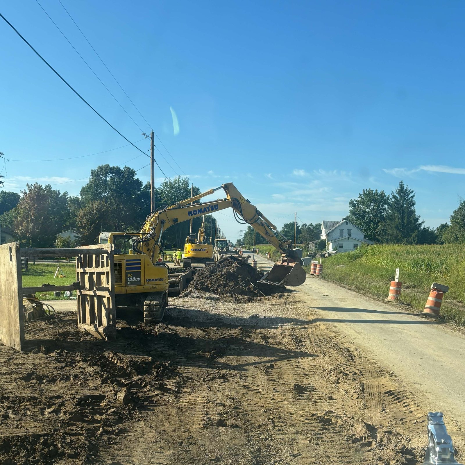 Trench box lowered in along the road shoulder