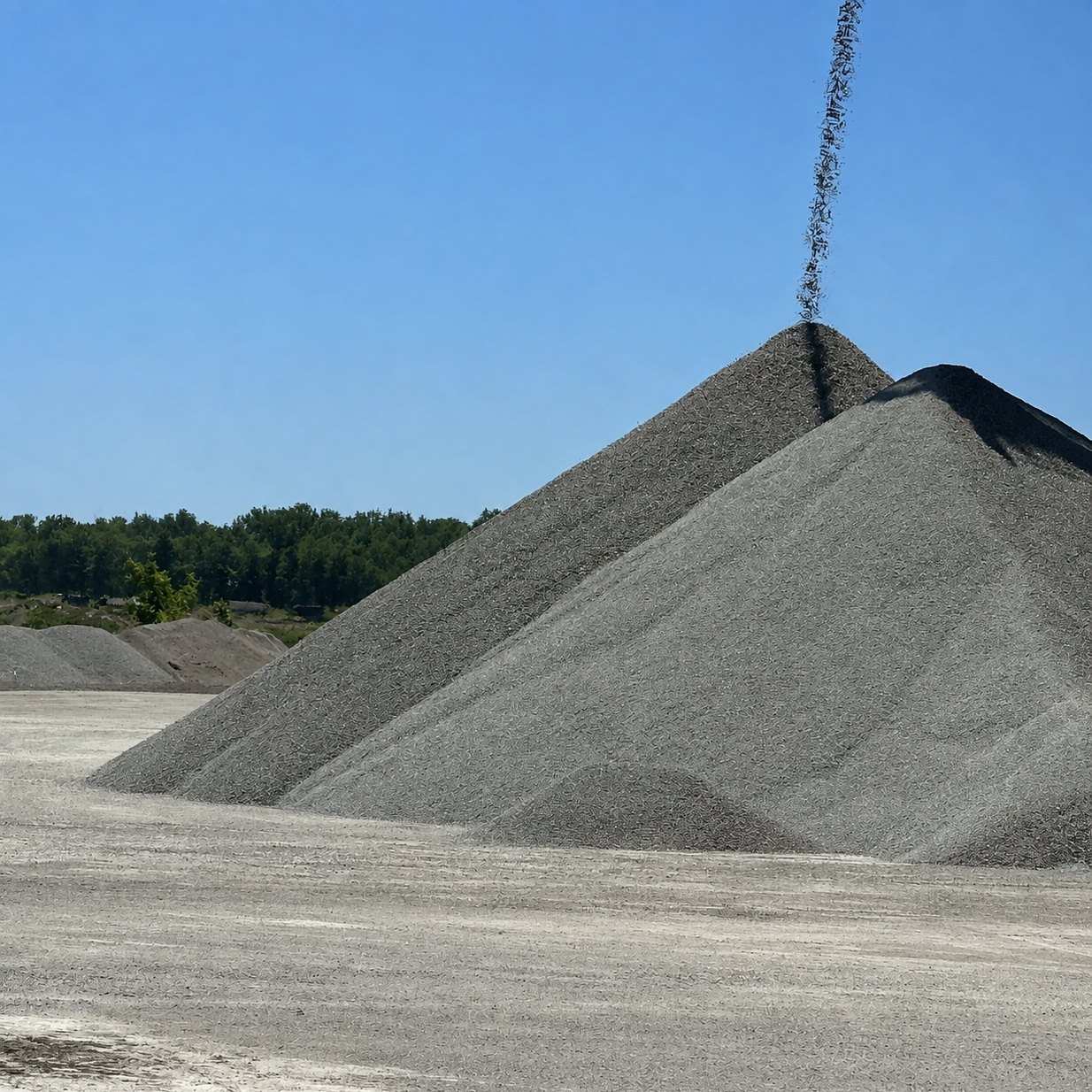 Stone stockpile rising under the conveyor drop