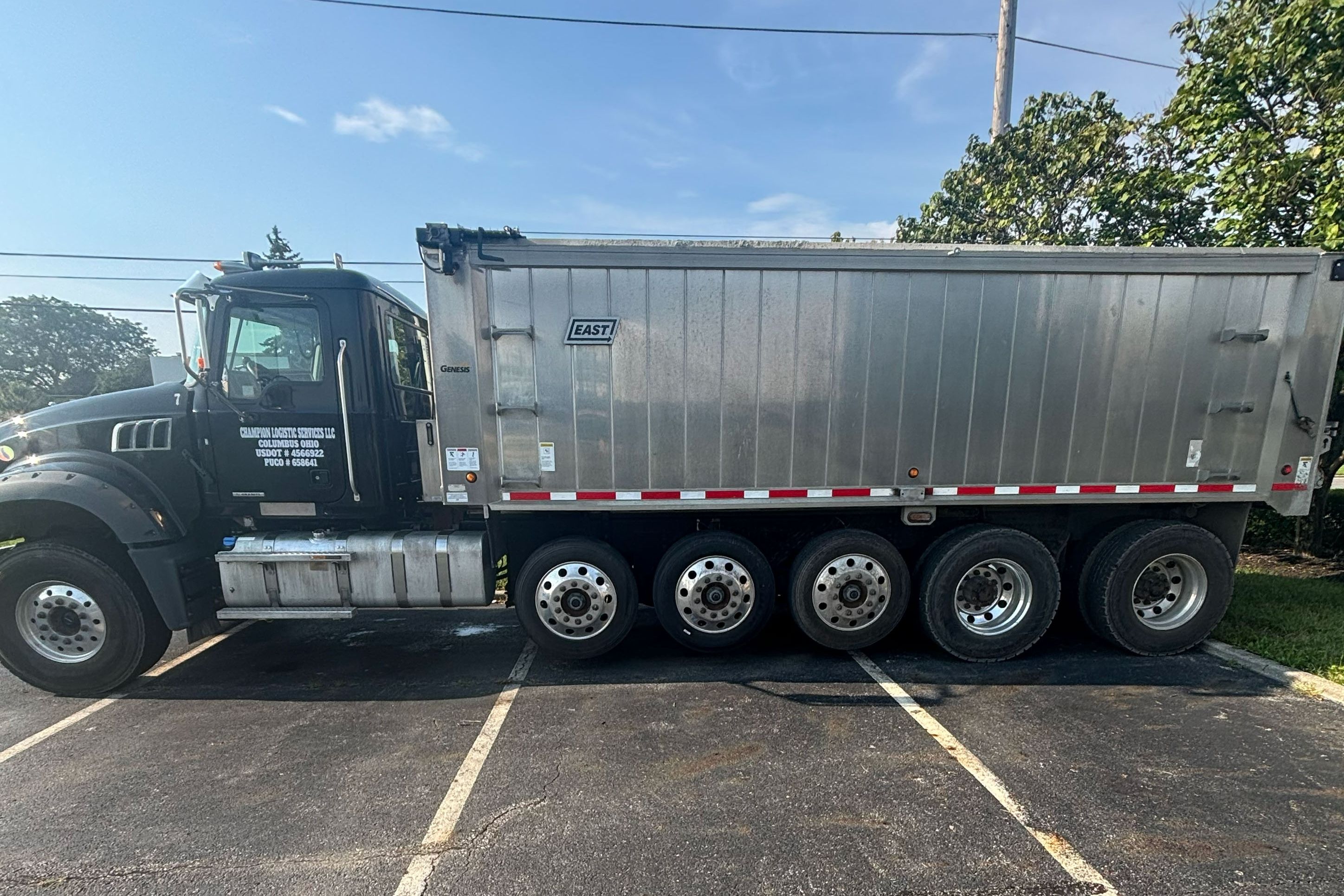 Silver dump body parked ahead of a cleanout